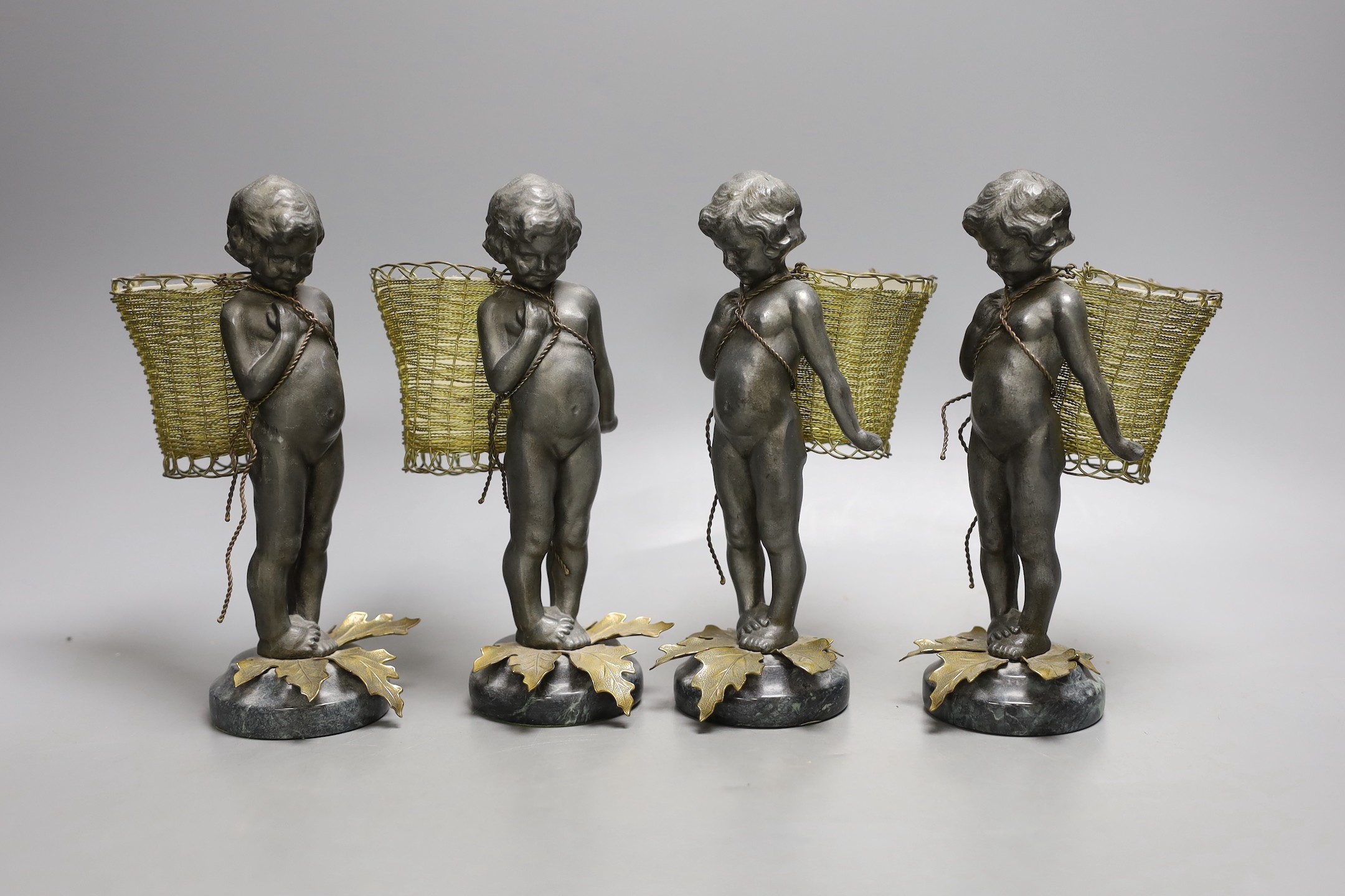 Four spelter and gilt metal ‘cherub’ posy vases, with glass liners, serpentine bases - 19cm tall